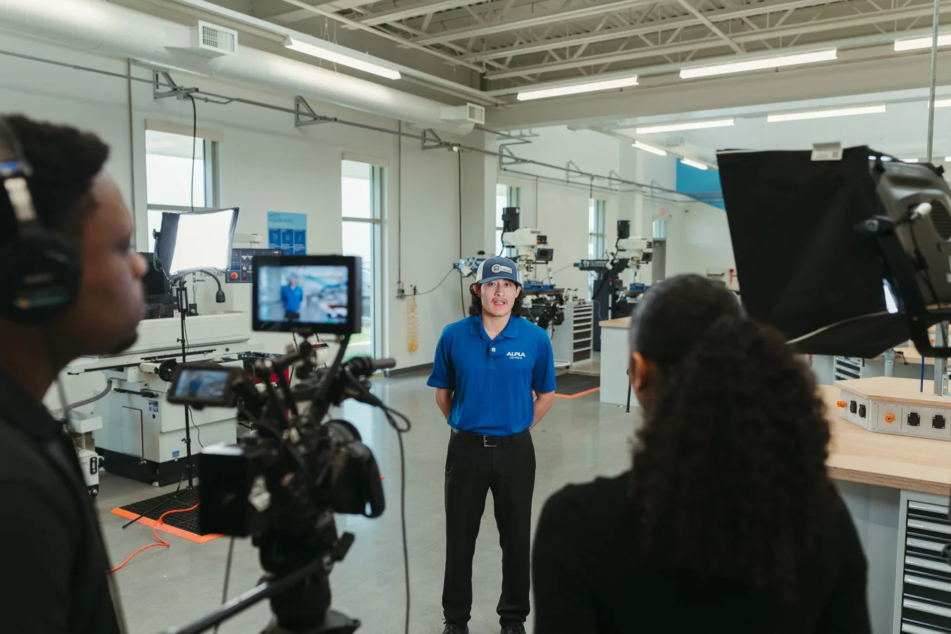 Crew with headphones and monitor filming a technician interview